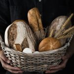 Artisanal baker holding a basket of baked goods