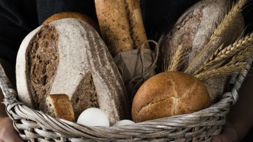 Artisanal baker holding a basket of baked goods
