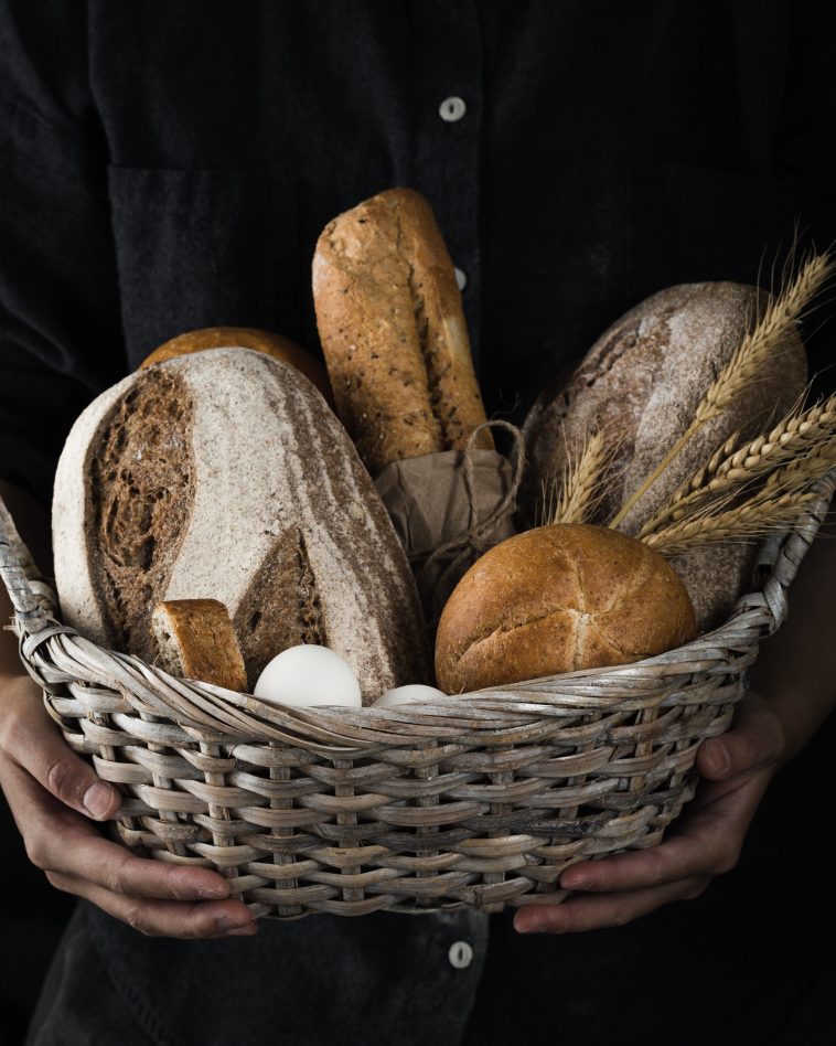 Artisanal baker holding a basket of baked goods