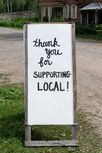 A street sign thanking customers for supporting local businesses