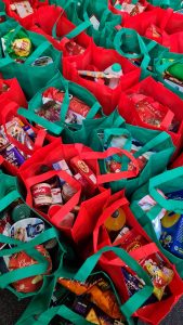 red and green bags filled with groceries for donation, building the power of brand community