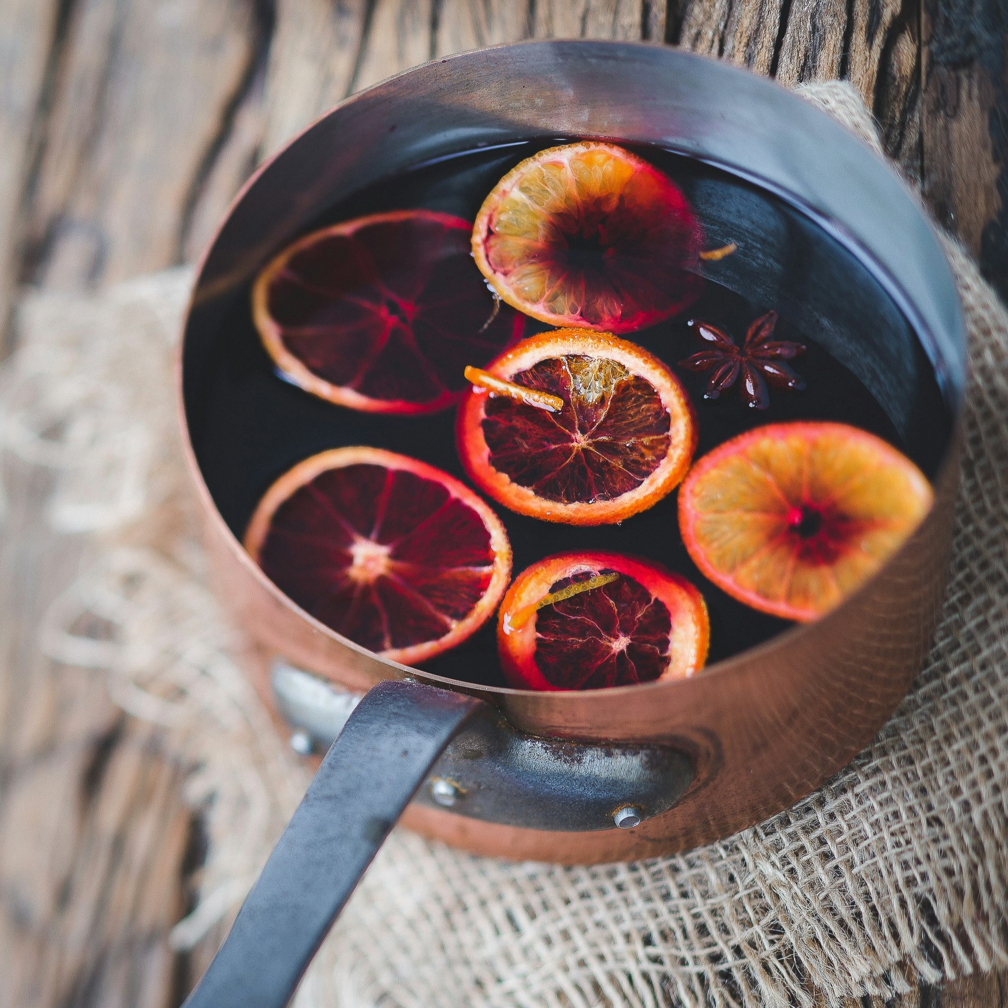 Pot with mulled wine and oranges